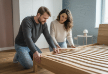 Comment bien choisir son sommier pour lit double ? Couple inspectant un lit double dans une chambre moderne